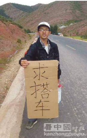 陈杭生在公路旁举起“求搭车”的纸板。（网络图片）