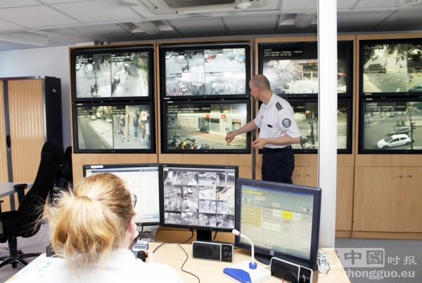 20区警察局安保摄像视频操作室内的专门负责视频巡逻的警员（左）和屏幕墙。（摄影：林莲怡/看中国）