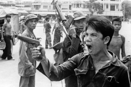1975年4月17日，一名红色高棉（柬共）士兵命令商铺店主们放弃他们的商店。（网络图片）