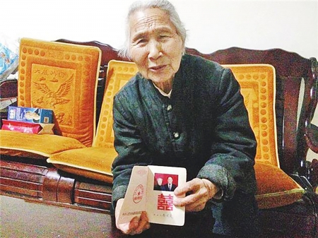 邢玉莲老人拿着她和赵国盛的结婚证。（网络图片）