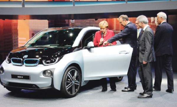 第65届法兰克福国际汽车展于12日开幕，德总理默克尔主持了开幕仪式。图为默克尔站在参展的全电动宝马BMWi3车旁。（AFP/Getty Images）