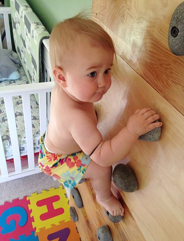 8个月大时，艾莉在婴儿房里攀爬小型婴儿用攀岩壁。（网络图片）