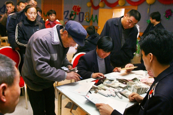 中国贫富差距高达234倍。图为在北京打工的人在领取被拖欠的工资。（Getty Images）