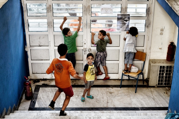 德国亚琛市一所收留难民的废弃学校里，难民儿童在校门口望着外面。（AFP/Getty Images）