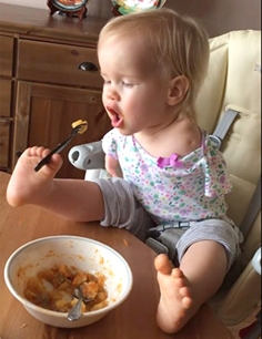 瓦希里纳用脚拿叉子学吃饭。(网络图片)