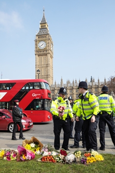 24日，伦敦警方将纪念鲜花从国会大厦移至国会广场。（Getty Images）