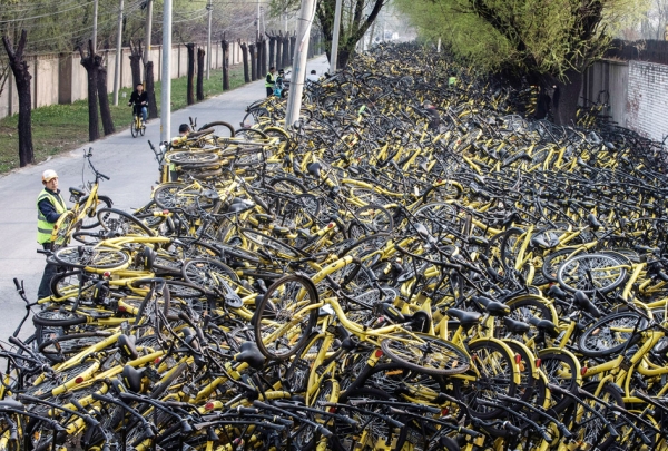 北京朝阳区一ofo共享单车维修点，一批数千辆受损的自行车停放在公司维修站外的街道上。（Getty Images)