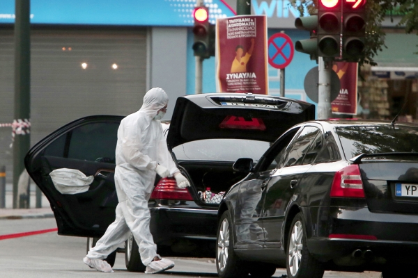法医专家正在帕帕季莫斯的车内及周围寻找证据。（AFP/Getty Images）