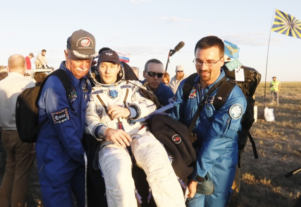 6月2日，地面工作人员抬着刚返回地球的法国宇航员佩斯凯。（AFP/Getty Images）