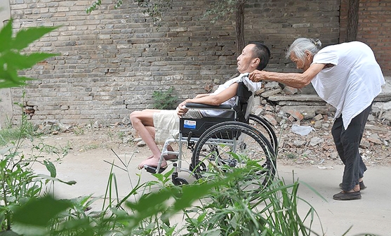 98岁老妈妈照顾瘫痪的儿子。