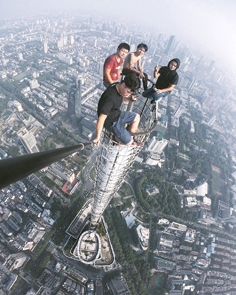 四名青年在毫无安全装备情况下，爬上89层高的江苏紫峰大厦顶进行自拍。（微博图片）