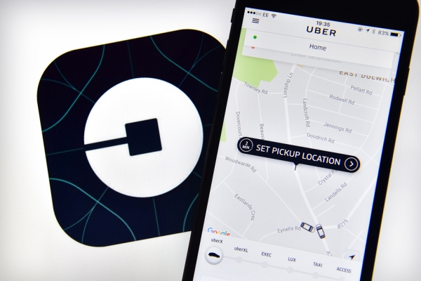 计算机屏幕上的Uber徽标及iPhone上显示的Uber主页。（Carl Court/Getty Images）