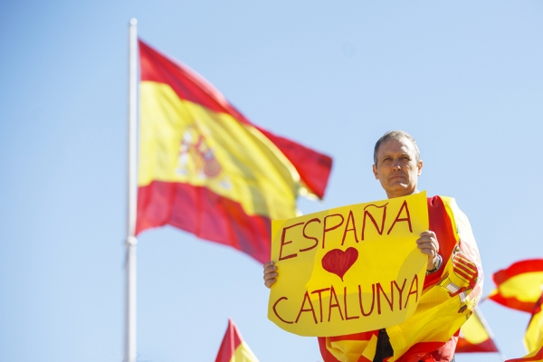 10月7日在马德里的集会上一男子手举“西班牙爱加泰罗尼亚”的标示牌，希望自己的国家不被分裂。 (Getty Images)