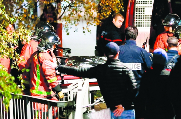 11月24日，消防员与警员在巴黎15区抬着被打死的老虎。(AFP/Getty Images)