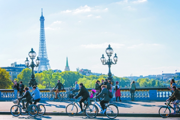 骑自行车的人与行人经过巴黎塞纳河上的亚历山大三世桥。(123RF)