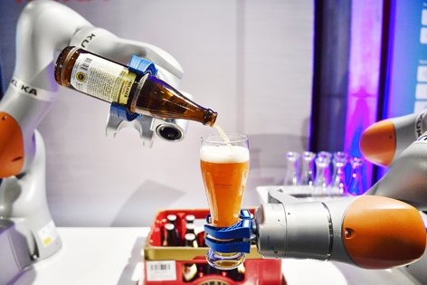 被中国美的收购的库卡公司生产的机器手臂在倒啤酒。（AFP/Getty Images）