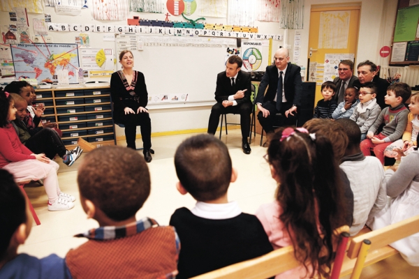 马克龙（中）与教育部长（中右）在巴黎19区的Emelie幼儿园。（AFP/Getty Images）