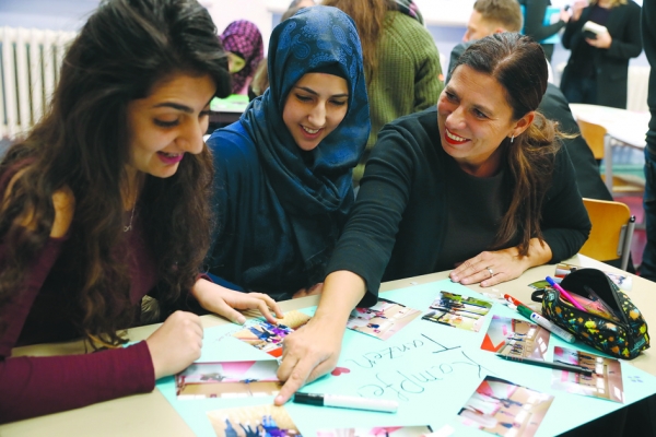 柏林给年轻难民提供语言课，老师Sandra Scheeres（右）在教两位学生。（Getty Images）