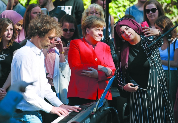一位穆斯林学生和德国总理默克尔自拍。（Getty Images）