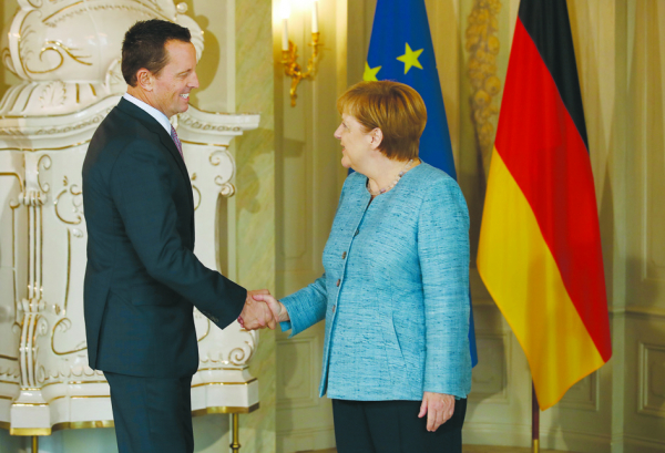 7月6日，美国驻德国大使格雷内尔（左）和德国总理默克尔（右）在德国的外交使馆招待会上握手。（Getty Images）