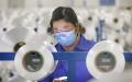 今年2月，一名带着口罩工作的江苏一纺织厂职工（AFP via Getty Images）