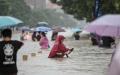 2021年7月20日，中国河南省郑州市人们在暴雨中涉水走过街道。（图片来源:Getty Images）