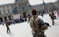 在阿拉斯恐袭事件后，法国反恐安全措施提升到最高警戒状态。图为在巴黎卢浮宫门口的反恐巡逻队。（EMMANUEL DUNAND/AFP via Getty Images）