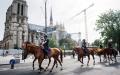 7月19日，巴黎奥运会开幕式前夕，法国宪兵和卡塔尔警察在巴黎市中心骑马巡逻，途径巴黎圣母院。（DIMITAR DILKOFF/AFP via Getty Images）