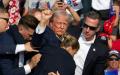 7月13日，川普中枪后，在保镖拥簇下离开集会现场。（图片来源：REBECCA DROKE/AFP via Getty Images）