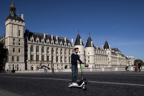 在巴黎塞纳河兑换桥(Pont au Change)上，共享电动滑板车巨头Lime法国公司总裁亚杰介(Arthur-Louis Jacquier)正骑着一辆电动滑板车。(AFP/Getty Images)