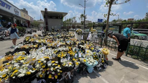 郑州市一名男子在地铁站前献花以纪念被洪水夺去生命的灾民。（图片来源:Getty Images）