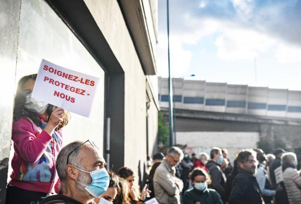 在巴黎警察局将数十名吸毒者从巴黎18区一公园转移到临近93省旁坦市附近，并砌墙封锁了一条连接巴黎与旁坦的隧道后，附近居民在被封隧道处举行抗议集会，要求政府承诺对长期存在的毒品祸害采取新的对策。一名抗议者手举写有“治疗他们，保护我们”的标语。（Photo by ALAIN JOCARD/AFP via Getty Images）