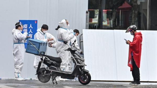 2022年3月17日，上海疫情爆发后外卖小哥送货（图片来源：HECTOR RETAMAL/AFP via Getty Images）