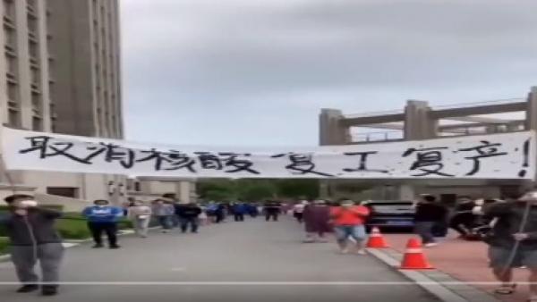 辽宁丹东防疫封控50天，丹东部分市民忍无可忍走上街头举横幅，高呼：“取消核酸 复工复产”。（图片来源：视频截图）