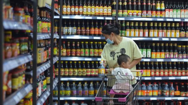  一名妇女带着孩子在超市购物。（图片来源：STR/AFP/Getty Images）