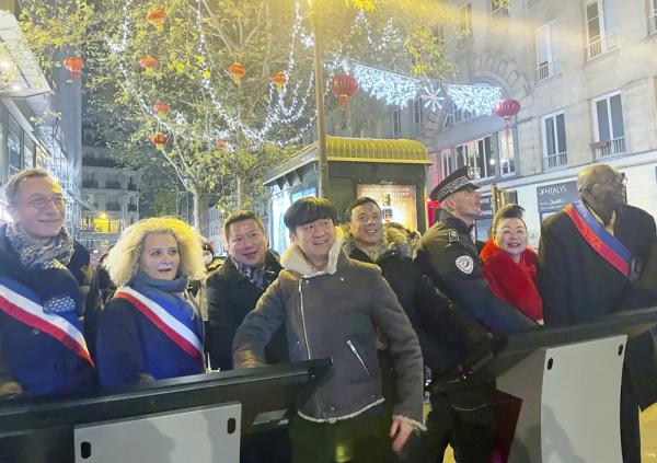 12月12日，美丽城联合商会点亮街区圣诞彩灯并为迎接中国新年挂上灯笼，巴黎19区区长达纽（左一）、10区区长高德芭女士（左二）、19区华人副区长王立杰（左三）、巴黎20区警察局长赫贡（右三）、20区副区长萨玛克（右一）与多位商会成员及侨领等各界人士参加了点灯仪式。