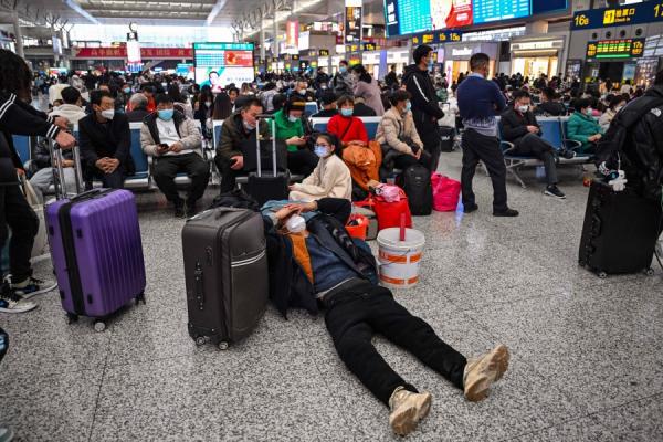 2023年1月11日，乘客在上海虹桥火车站等候火车返回家乡庆祝黄历新年。（图片来源：HECTOR RETAMAL/AFP via Getty Images）