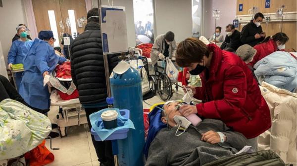 上海同仁医院里一位女士正在照顾病人。（HECTOR RETAMAL/AFP via Getty Images）