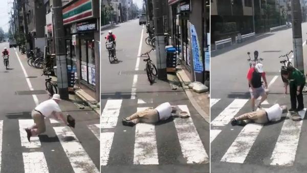 日本街头，一名老人摔倒在地，经过的路人前来帮助老人。