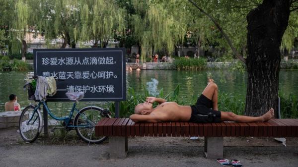 2022年7月7日北京高温天气，市民湖里游泳、湖边纳凉。（图片来源：Getty Images）