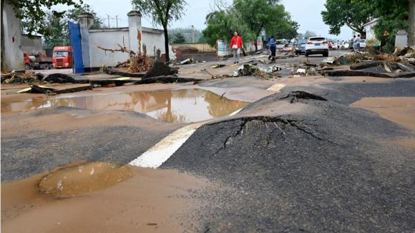 图为2021年河南省郑州连日发生严重洪水导致道路下沉。（图片来源： JADE GAO/AFP via Getty Images）