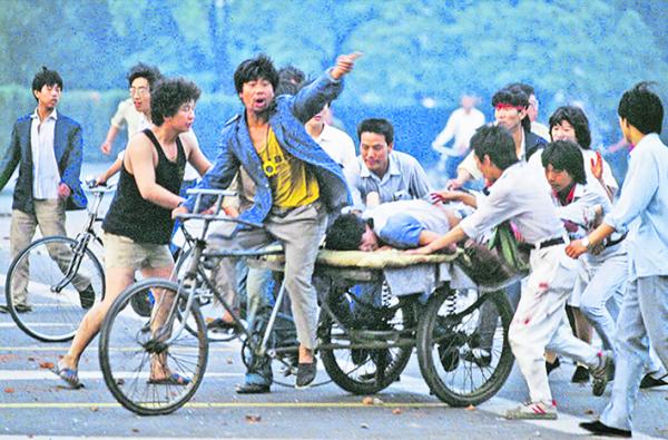 六四事件中，民众抢救受伤的学生。（Jacques Langevin/Getty Images）