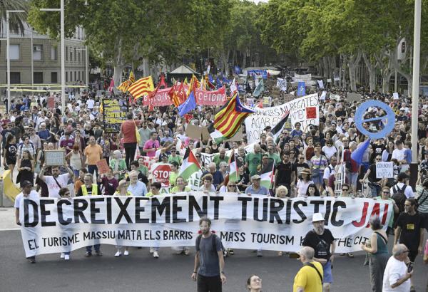 7月6日，巴塞罗那示威者举着“减少旅游业”的标语，上街游行。(JOSEP LAGO/AFP via Getty Images)