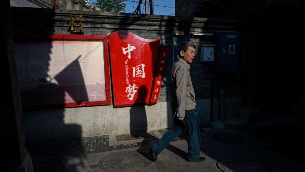 2022年10月6日，一名北京市民走过“中国梦”宣传标语牌。（图片来源：Getty Images）