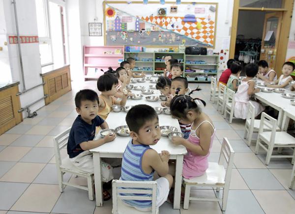 2004年8月5日，北京一家幼儿园学生在享用早餐。（Getty Images）