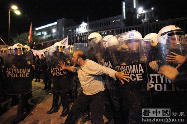 示威期间，抗议者试图阻止防暴警察冲进前ERT总部。（AFP/Getty Images)