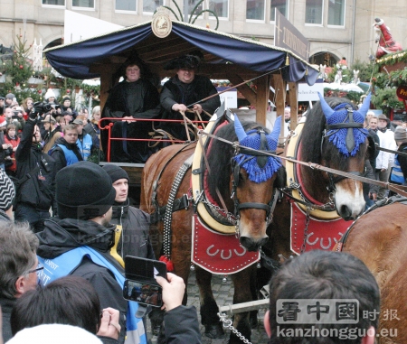 游行队伍中装载着圣诞果脯蛋糕的马车。（摄影：安迪/看中国）