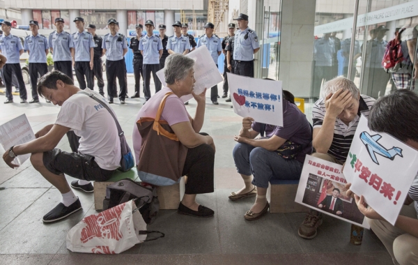 在马国总理纳布吉宣布发现的残骸来自失踪的马航MH370飞机后，马航MH370的部分中国遇难者亲属8月6日聚集在北京的马航办公室外，表达愤怒和怀疑。图为部分家属在