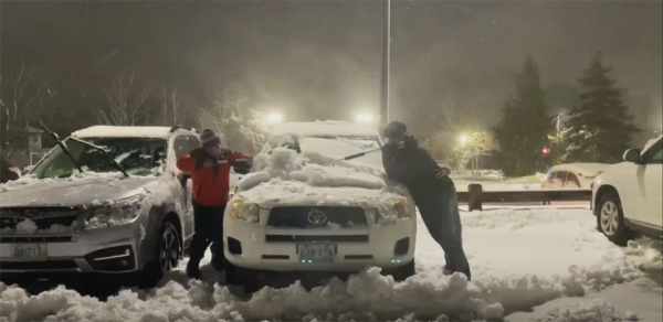 克瑞斯丁（左）和安碧为刚下班的医务人员清理车窗上的积雪。（视频截图）