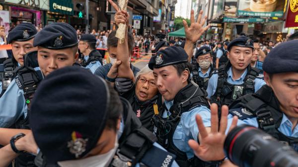 王婆婆手持鲜花到铜锣湾，随即被警方带上警车。（图片来源：Getty Images）